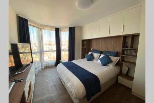 a bedroom with a large bed and a television at Studio 13 in Varna City
