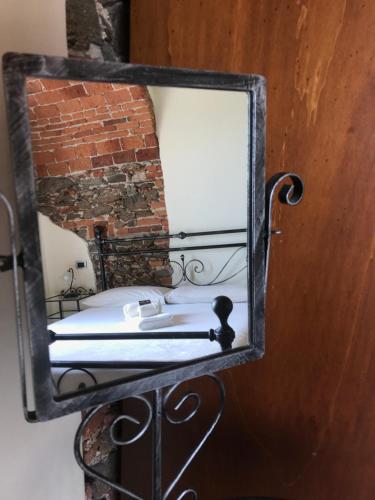 a mirror hanging on a wall with a bed at B&B Villa Antilia in Busca