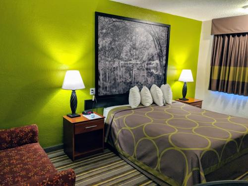 a bedroom with a bed and a lamp at Super 8 by Wyndham Lake City in Lake City
