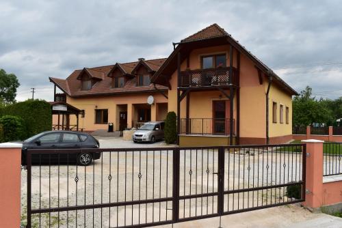 a house with two cars parked in front of it at Penzion Zuzka in Krásnohorská Dlhá Lúka