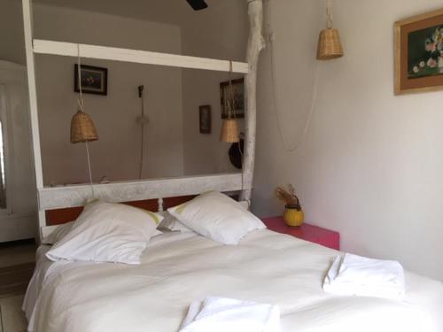 a bedroom with a white bed with two pillows at Hôtel Lido Beach in Hyères