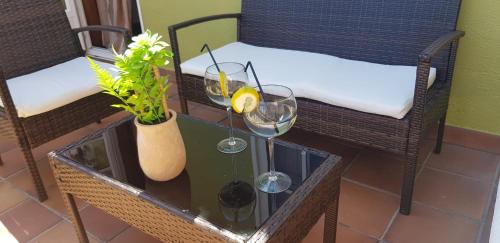 una mesa con dos copas de vino y una planta en Casa Cordieira, en Combarro