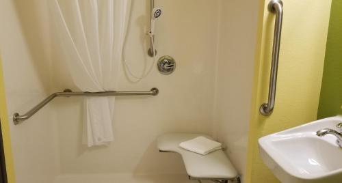a bathroom with a shower and a toilet and a sink at Microtel Inn & Suites by Wyndham Delphos in Delphos