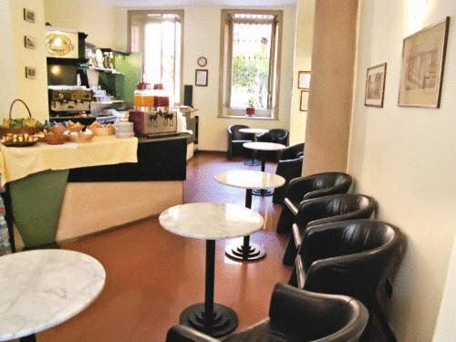 a waiting room with chairs and tables in a salon at Hotel Minerva in Milan