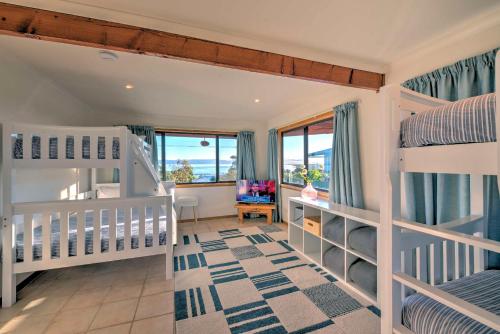 a bedroom with two bunk beds and a balcony at Zenith in Coles Bay
