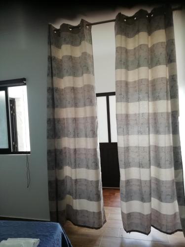 a pair of curtains in a room with a window at Vivenda Palheiras in Roncão