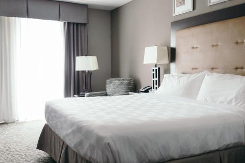 a hotel room with a large bed and a window at Holiday Inn and Suites East Peoria by IHG in Peoria