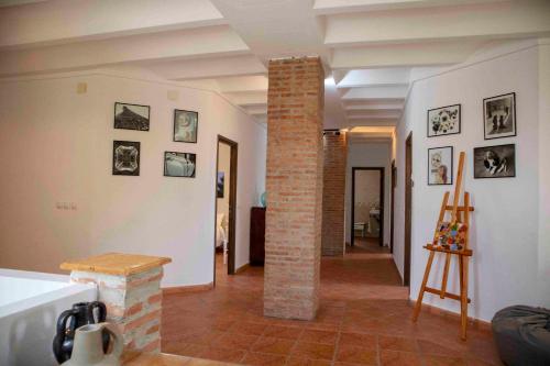 a living room with a brick pillar with pictures on the walls at Caserío Lo Bulle in Oria