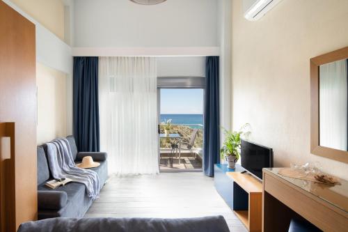 a living room with a view of the ocean at Almare Seaside Studios & Suites - Sarti Sithonia in Sarti