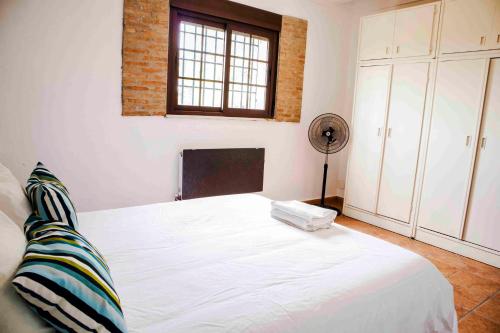 a bedroom with a white bed and a window at Caserío Lo Bulle in Oria