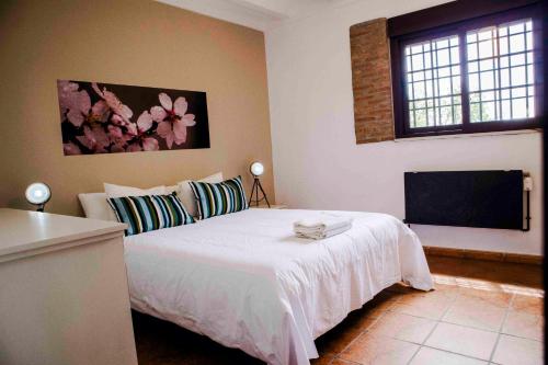 a bedroom with a white bed and a flat screen tv at Caserío Lo Bulle in Oria