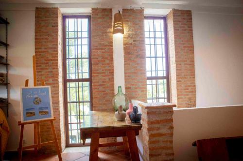 a room with two windows and a table with a vase on it at Caserío Lo Bulle in Oria