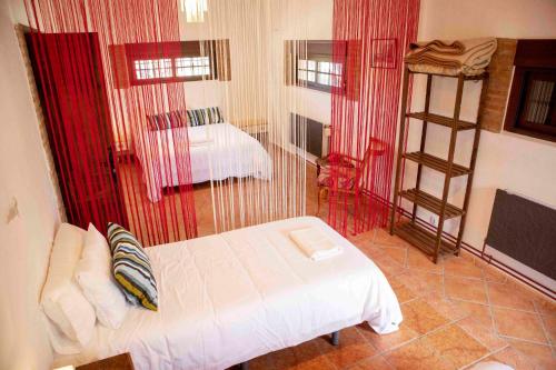 a room with a bed in a room with red curtains at Caserío Lo Bulle in Oria
