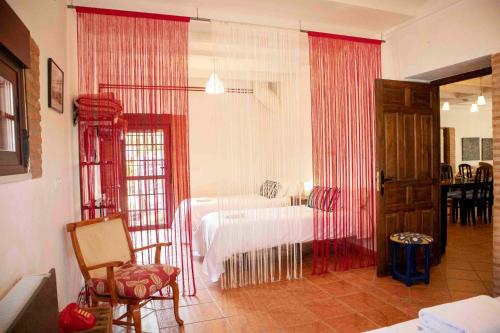 a bedroom with a bed with red drapes at Caserío Lo Bulle in Oria