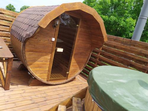 a small wooden dog house on a deck at Szilvia Panzió Gyomaendrőd in Gyomaendrőd