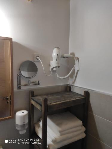 a bathroom with a mirror and a pile of towels at Finca La Calancha in Cuerva