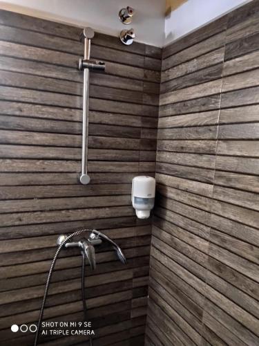 a shower in a bathroom with a wooden wall at Finca La Calancha in Cuerva