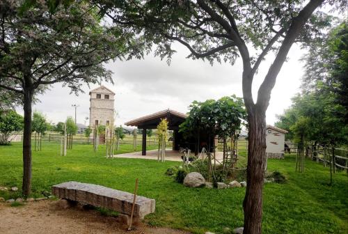 a park with a bench and a tower in the distance at Finca La Calancha in Cuerva