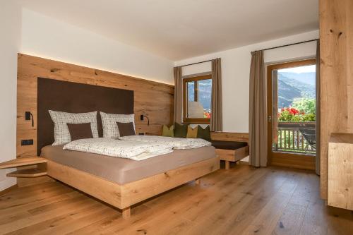 1 dormitorio con cama y ventana grande en Ferienwohnungen Trogerhof, en Ora - Auer