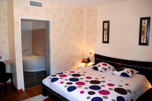 a bedroom with a bed and a bath tub at La Gourmandine in Châtellerault