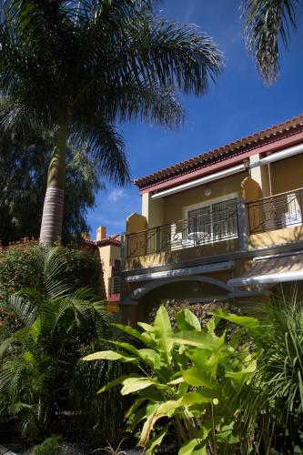a building with a balcony and a palm tree at Residencial El Llano in Valle Gran Rey