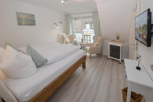 a bedroom with a bed and a living room at Hotel-Pension Achtern Diek in Büsum