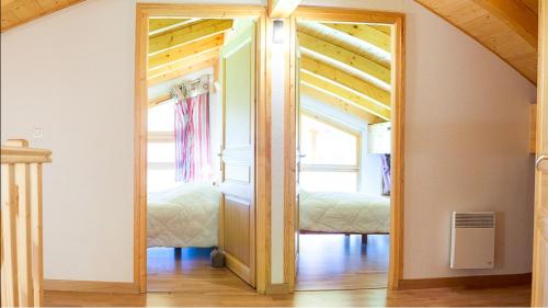 a mirror in a room with two beds at Les Pins - Apt 11 - BO Immobilier in Châtel