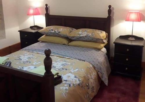 une chambre avec un lit avec deux tables de nuit et deux lampes dans l'établissement countryside lavender cottage, à Saint-Julien-dʼEymet