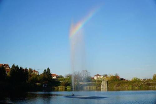 a rainbow in the middle of a lake with a fountain at Sobe Lara in Gradačac