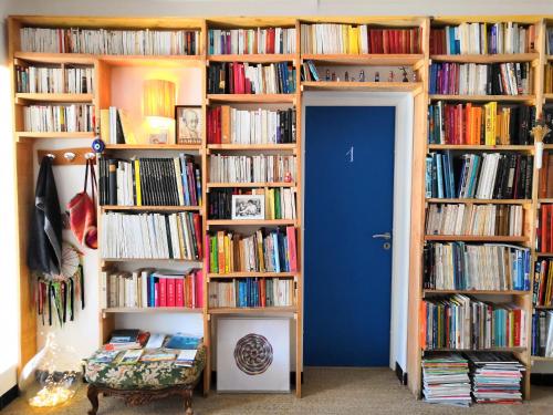a room with several shelves filled with books at Hôtel Lido Beach in Hyères