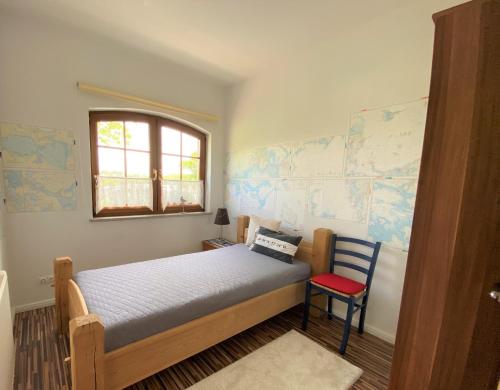 グロヴェにあるVilla Schlossalleeの小さなベッドルーム(ベッド1台、赤い椅子付)