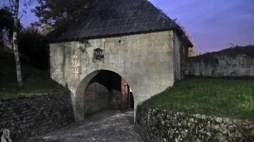 an old stone building with an archway in a field at Sobe Lara in Gradačac