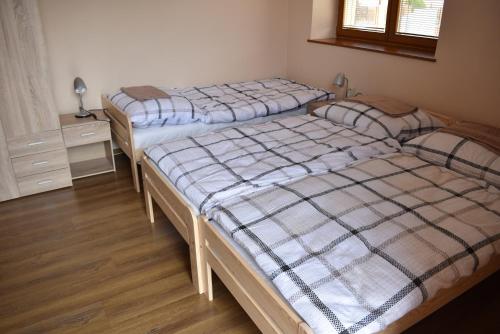 a bedroom with two beds and a desk with a window at Penzion Zuzka in Krásnohorská Dlhá Lúka