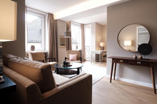 a living room with a couch and a mirror at SAXX Apartments "Goldberg Karree" in Hagen