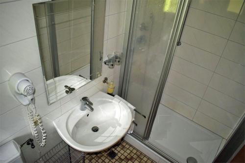 y baño con lavabo blanco y ducha. en Waldgasthof Altersbach en Waldkirch