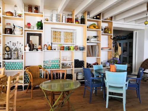 uma sala de jantar com mesas, cadeiras e prateleiras em Hôtel Lido Beach em Hyères