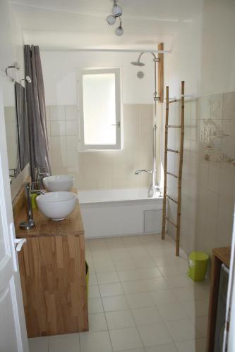 een badkamer met een bad, een wastafel en een bad bij Gîte L'oliveraie d'Aniane 7 personnes in Aniane