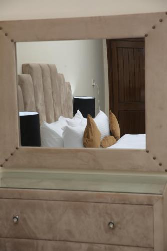 a mirror on top of a bed in a bedroom at Premier Inn Grand Gulberg Lahore in Lahore