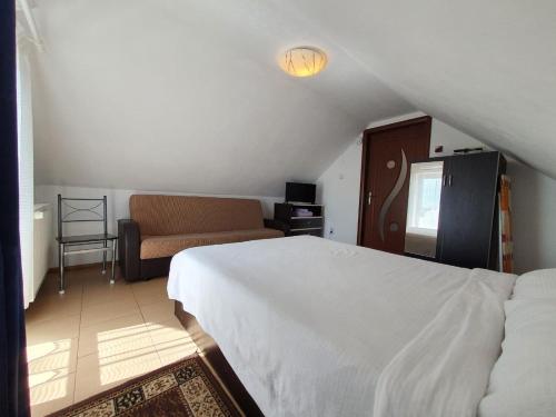 sypialnia z białym łóżkiem i kanapą w obiekcie Charter Apartments Costea w Sybinie