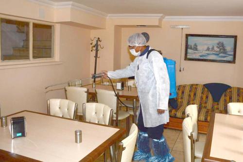 a person standing in a room with a table and chairs at Aygun Hotel Avanos in Avanos