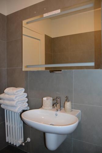 y baño con lavabo, espejo y toallas. en Appartamento Tergesteo, en Trieste