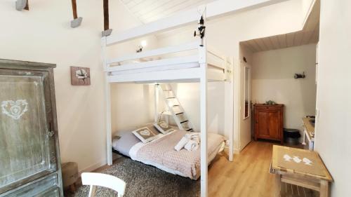 une chambre avec un lit superposé et un bureau dans l'établissement Les Althéas, à Villers-sur-Mer