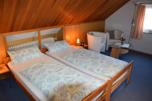 a bedroom with two beds and a table and a chair at Pension Wiesner in Hameln