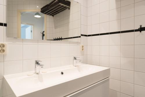a white bathroom with a sink and a mirror at Central Rooftop Terrace Guest Suite in Amsterdam