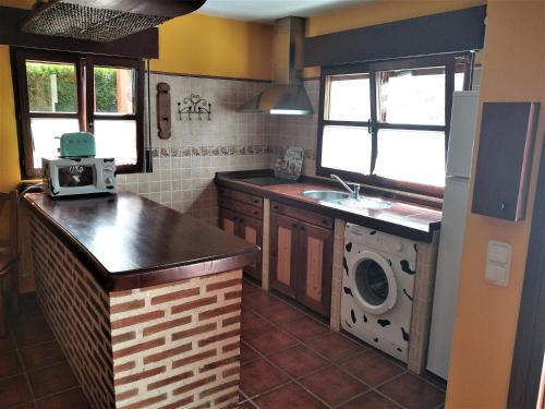 ポオ・デ・リャネスにあるCasa El Pilpayuのキッチン(シンク、洗濯機付)