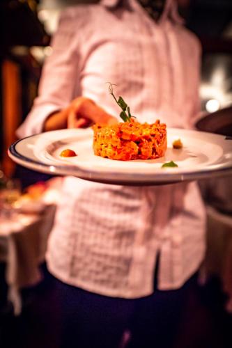 a person holding a plate with a piece of food at Hotel de Charme Römerhof in Arbon