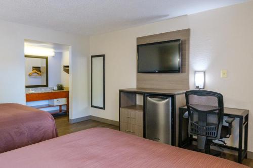 a hotel room with two beds and a flat screen tv at Red Carpet Inn Washington DC in Washington