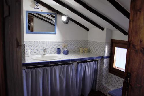 ein Bad mit einem Waschbecken und einem Spiegel in der Unterkunft Sui tetti del borgo in Capranica