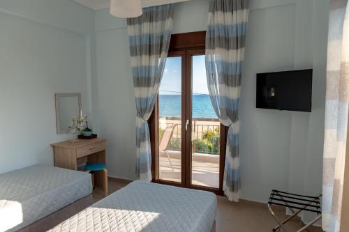 a room with two beds and a window with a view at Dimi Seafront Apartment by Rentals Pro - Nea Moudania in Nea Moudania