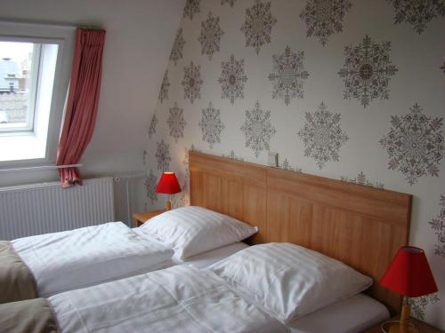 a bedroom with two beds and a window and wallpaper at Rho Hotel in Amsterdam